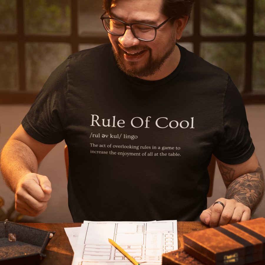 Paul at the table in a Rule of Cool tee